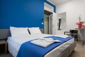 um quarto azul com uma cama com toalhas em Suemy Rome B&B em Roma
