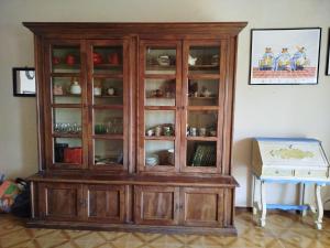 a wooden cabinet with glass doors in a room at Sea View Apartment with Terrace & Free Parking in San Lorenzo al Mare