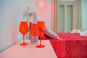 two glasses on a table next to a bed at La Casa con il Cuore in Brindisi