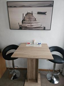 a wooden table with two chairs and a picture of a pier at Zimmervermietung Schöne Gasse 6 in Freiberg