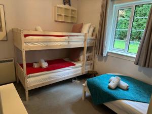ein Kinderschlafzimmer mit 2 Etagenbetten und einem Fenster in der Unterkunft Highland cottage Fort William in Fort William