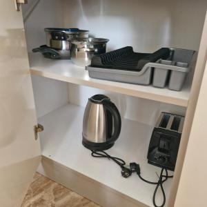 un garde-manger avec un appareil sur une étagère dans l'établissement Villa Sardinia Sveti Vlas Studio, à Sveti Vlas