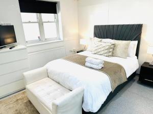a bedroom with a white bed and a couch at Westferry Two-Bedroom Deluxe Apartment in London