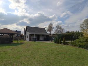 a house with a grassy yard in front of it at Domek na Mazurach in Pisz