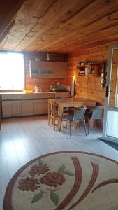 a kitchen and dining room with a table in a cabin at Domek na Mazurach in Pisz