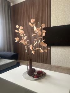 a vase with a plant on a table in a room at Apartman Tara in Subotica