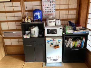 a small kitchen with a refrigerator and a microwave at Sudo Nousaien in Koriyama