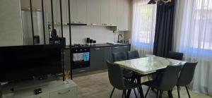 a kitchen and dining room with a table and a television at My House in Borjomi