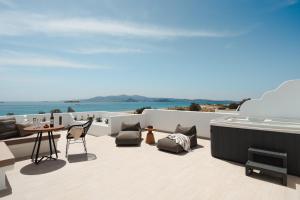 a balcony with a table and chairs and the ocean at Almiriki Naxos Beachside Living in Plaka