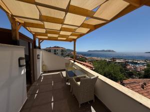 a balcony with a table and chairs and the ocean at The Townhouse Apartment in Kas