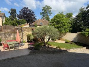 a patio with a table and chairs and a tree at Chambre La Dracysienne in Dracy-le-Fort