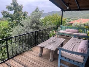 Una terraza de madera con una mesa y un banco encima. en Sayfiye Butik Otel, en Köyceğiz
