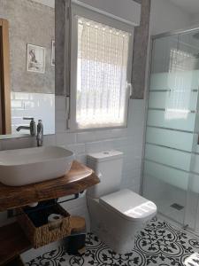 a bathroom with a sink and a toilet and a window at "La casuca de Finu" #1# Santillana del Mar in Arroyo +6 photos