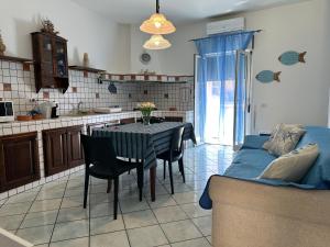 a kitchen and dining room with a table and a couch at AMATI HOLIDAYS in Palermo