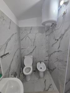 a white bathroom with a toilet and a sink at Star Room's in Vlorë +30 photos