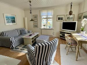 a living room with two couches and a television at Bagarestigen bargel punkt s e in Lysekil