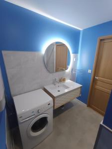 a bathroom with a washing machine and a sink at Gîte au cœur des châteaux de la Loire in Francueil