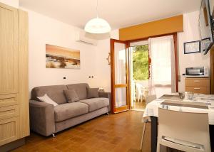 a living room with a couch and a kitchen at Villa Lucia in Lignano Sabbiadoro