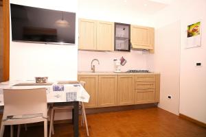 a kitchen with wooden cabinets and a table with chairs at Villa Lucia in Lignano Sabbiadoro +7 photos