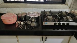 a stove top with pots and pans and utensils on it at Hill View Quads Villa in Lonavala