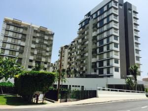 a large apartment building in front of a street at By the Sea PENTHOUSE duplex in Batu Ferringhi