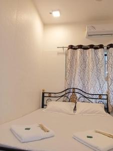 Un dormitorio con una cama con dos toallas encima. en Hill View Quads Villa, en Lonavala