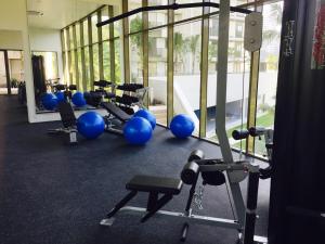 a gym with a row of exercise equipment in a building at By the Sea PENTHOUSE duplex in Batu Ferringhi
