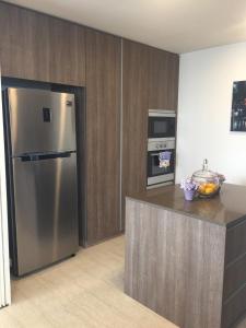 a kitchen with a stainless steel refrigerator and an oven at By the Sea PENTHOUSE duplex in Batu Ferringhi