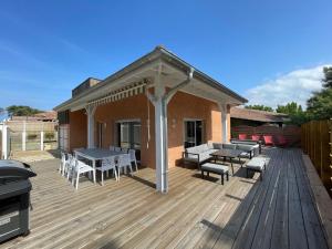 a deck with tables and chairs and a grill at Villa Sur La Dune Moliets, 12 people, beach, golf in Moliets-et-Maa
