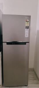 Un refrigerador plateado en una cocina con un cartel. en Hill View Quads Villa, en Lonavala