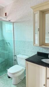 a bathroom with a toilet and a shower and a sink at Residencial Amora in Canela