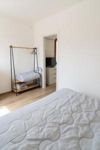 una camera da letto bianca con un letto e una televisione di Francesco&Chiara - Sweet Apartment a Chioggia