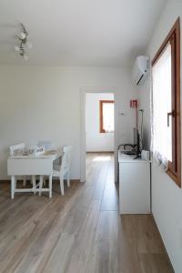 un soggiorno bianco con un tavolo e una sala da pranzo bianca di Francesco&Chiara - Sweet Apartment a Chioggia