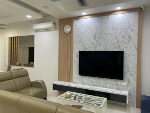 ein Wohnzimmer mit einem Flachbildfernseher an der Wand in der Unterkunft Seri Hayzar Homestay in Gua Sai