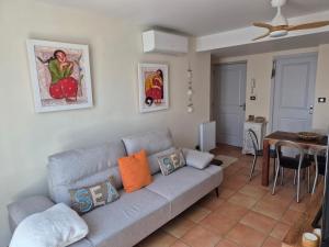 een woonkamer met een grijze bank en een tafel bij Appartement Syrah in Collioure