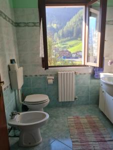 a bathroom with a toilet and a sink and a window at Apartamento Pino Verde in San Colombano VT Vista, Natura, Wifi in San Colombano