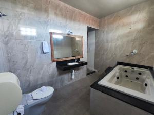 a bathroom with a tub and a toilet and a sink at Pousada Flor de Lis in Diamantina +264 photos