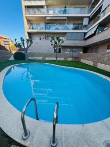 duży niebieski basen przed budynkiem w obiekcie Magnífico piso con piscina y terraza grande cerca de la playa w Lloret de Mar