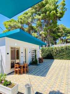 a house with a blue roof and a patio at "Seaside Pines" Apartments in Vlorë