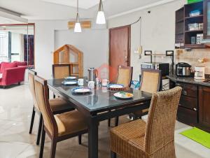 ジャカルタにあるLarge 3BR Rasuna Apt with Pool & Wi-Fi by 2ndHomeのテーブルと椅子のあるダイニングルーム
