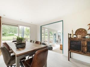 a dining room with a table and chairs and a mirror at The Blue House - Heerlijk aan het Water in Ooltgensplaat +29 photos