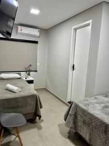 Una habitación de hospital con dos camas y una ventana. en Della Economy Hotel, en Paranaguá