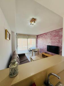 salon z kanapą i stołem w obiekcie Magnífico piso con piscina y terraza grande cerca de la playa w Lloret de Mar