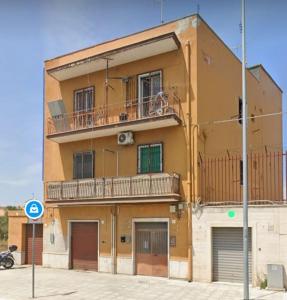 un edificio amarillo con balcón en la parte superior en Il Sorriso, en Bari