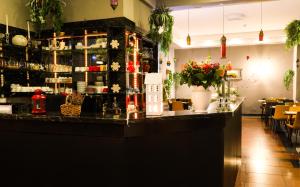 a bar in a restaurant with flowers on the counter at Hotel Karlshorst in Berlin