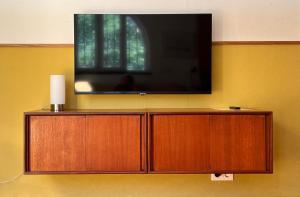 een flatscreen-tv die bovenop een muur staat bij Arriba stijlvol appartement met zwembad en tuin in Conil de la Frontera