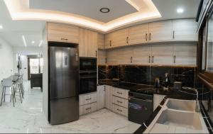 a kitchen with a stainless steel refrigerator and cabinets at Sea view maisonette Chloraka in Khlorakas