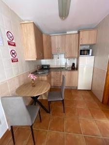 małą kuchnię z drewnianym stołem i krzesłami w obiekcie Apartamento en Frigiliana w mieście Frigiliana