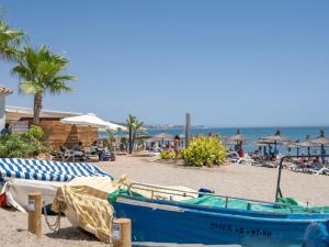 Un barco azul en una playa con gente. en Pass the Keys Chic Retreat in the heart of La Cala, en La Cala de Mijas