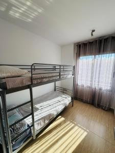 sypialnia z dwoma łóżkami piętrowymi i oknem w obiekcie Magnífico piso con piscina y terraza grande cerca de la playa w Lloret de Mar +19 zdjęć